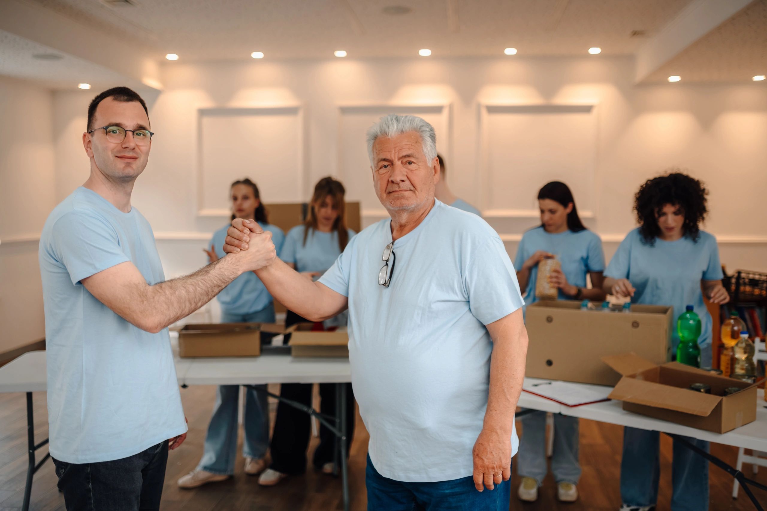 Community members and volunteers joining hands at a local charity event